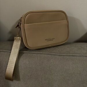 Beige crossbody pouch by RevitaLash Cosmetics